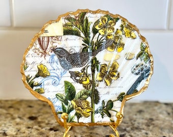 Decoupage abstract bird and floral pattern on a hand painted flat scallop shell.