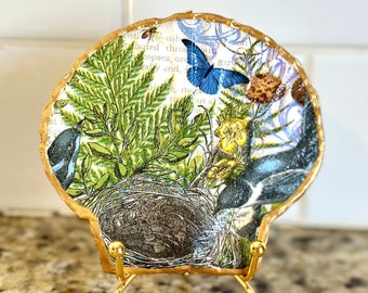 Decoupage abstract bird and floral pattern on a hand painted flat scallop shell. Gold display stands additional.