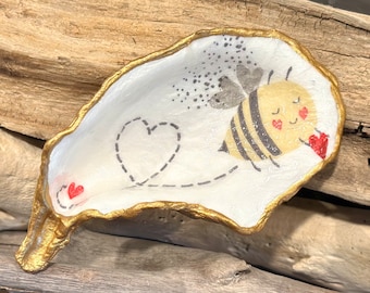 Decoupage bumblebee pattern on a real, flat oyster shell, beach combed along Florida’s Atlantic coast.