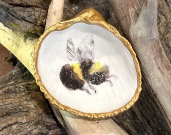 Decoupage bumble bee on a painted, real cockle shell, beach combed along Florida’s Atlantic coast. Shown on 4” gold stand (additional cost).