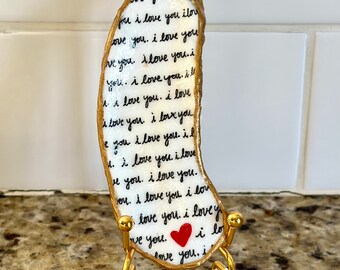 Decoupage “I love you” pattern on a hand painted oyster, beach combed on Florida’s Atlantic coast. Gold display stand additional.