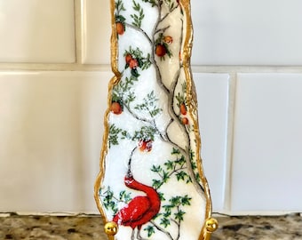Decoupage scarlet red ibis and orange tree pattern on a hand painted oyster, beach combed on Florida’s Atlantic coast. Display stand extra.