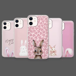 May include: A collection of five pink phone cases. Each case features a different Easter-themed design, including bunny illustrations, heart patterns, and the words "Happy Easter". The cases are made of a clear, protective material.