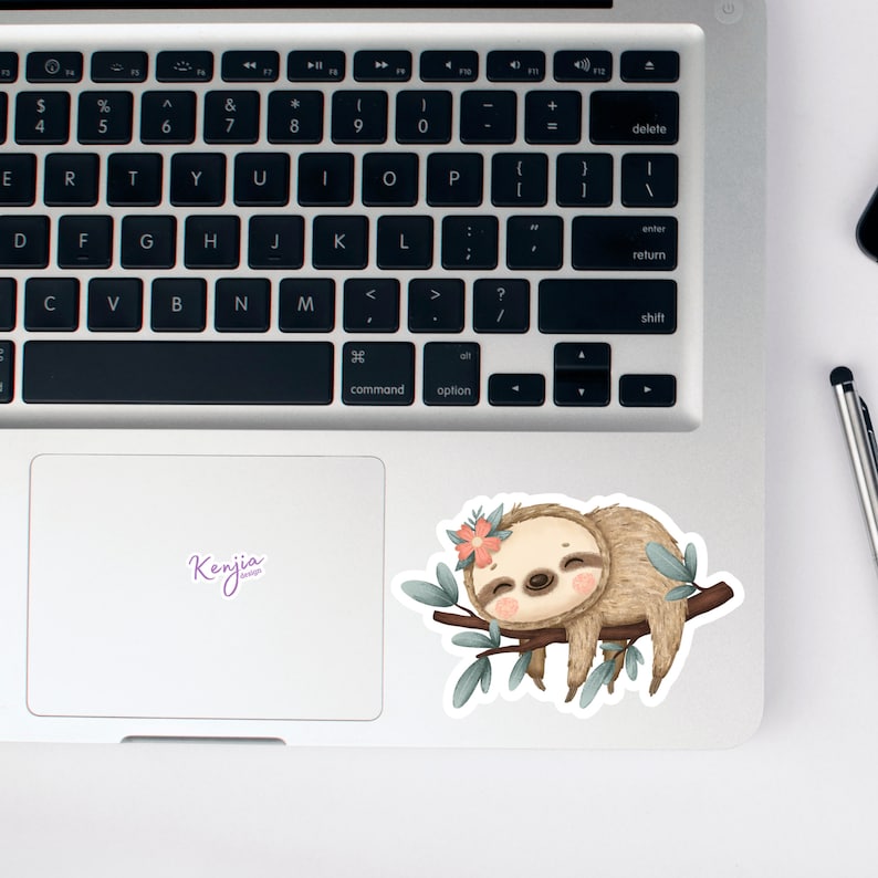 May include: A cute cartoon sloth with a pink flower on its head is sleeping on a branch with green leaves. The sloth is brown and has a white belly. The background is a white laptop.