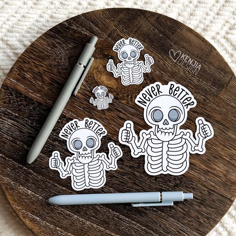 May include: Four white skeleton stickers with the text "Never Better" on a wooden surface. The skeletons are all giving a thumbs up.