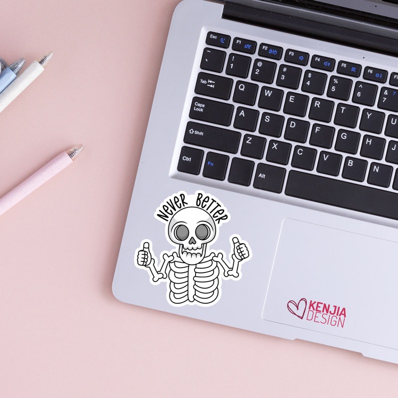 May include: A white sticker with a cartoon skeleton with a skull and crossbones. The skeleton is giving a thumbs up with both hands. The text "Never Better" is written in a circle around the skeleton.