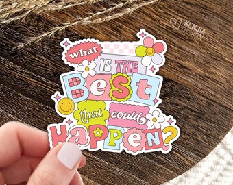 May include: A die-cut vinyl sticker featuring the text "what IS THE BEST that could happen?" in a colourful, layered typography style. The design includes pastel pink, blue, yellow, and green accents, with small flower and smiley face icons.