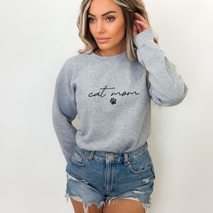 May include: A gray sweatshirt with the text "cat mom" and a paw print in black.