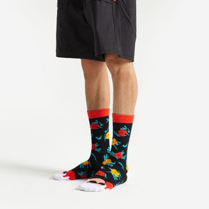 May include: A pair of black socks with a colorful floral pattern. The socks have a red and white trim at the top.