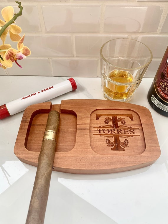 A matched set of custom-engraved cigar ashtray and whiskey glass is a genuinely thoughtful, coordinated gift that feels intentional rather than generic.