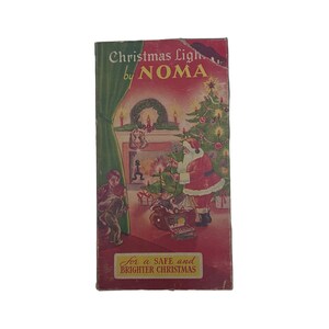 May include: Vintage Christmas light box featuring a red and green illustration of Santa Claus decorating a Christmas tree with lights. The box reads "Christmas Lights by Noma" and "For a Safe and Brighter Christmas".