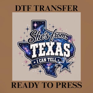 Pode incluir: Uma transferência DTF pronta para prensar com o contorno do estado do Texas preenchido com uma estampa de galáxia azul. O texto diz She's from TEXAS I CAN TELL. Inclui um emblema de estrela azul e branco e vários pequenos detalhes de estrelas em branco e rosa.