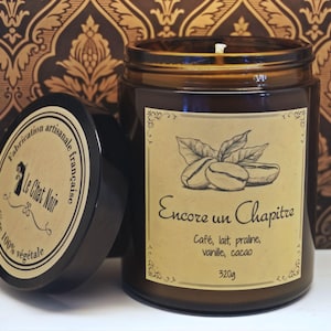 Pode incluir: Um frasco de vela de vidro castanho com tampa preta, com um rótulo que diz Encore un Chapitre, Café, lait, praline, vanille, cacao, 320g. A tampa diz Fabrication artisanale française, Le Chat Noir, Cire 100% végétale.