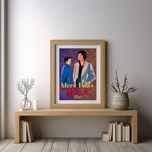 Puede incluir: Un p&oacute;ster enmarcado con un fondo morado que presenta a dos hombres en un estilo vintage. Los hombres visten trajes y el p&oacute;ster tiene el texto "Mere Paas Maa Hai" en rojo y blanco.