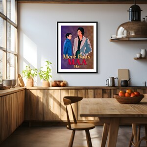 Puede incluir: Un p&oacute;ster enmarcado con un fondo morado y marr&oacute;n que presenta a dos hombres en un estilo vintage. El texto en el p&oacute;ster dice "Mere Paas Maa Hai".