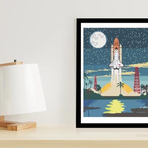 Op de afbeelding: Een ingelijste illustratie van een spaceshuttle die de lucht in schiet in een sterrenhemel met volle maan. De shuttle wordt omringd door palmbomen en een waterpartij.