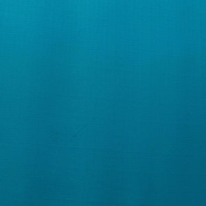 May include: A solid teal blue background with a subtle textured pattern.