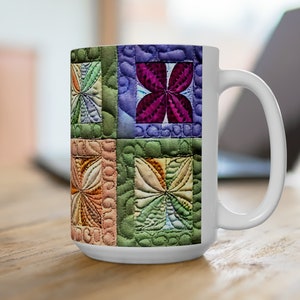 May include: White ceramic mug with a colorful patchwork design featuring a variety of floral patterns in shades of green, purple, pink, and orange.