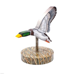Op de afbeelding: Een houten eendenlokvogel met beschilderde details, geperst op een basis met een bruin en beige grasachtig ontwerp.