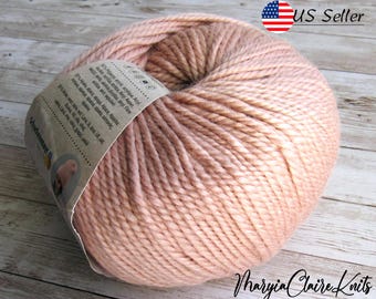 May include: A skein of soft, light pink yarn. The yarn is made of 100% superwash merino wool and is perfect for knitting or crocheting.