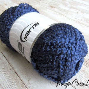 May include: A ball of dark blue yarn with a white label that says "yarns".