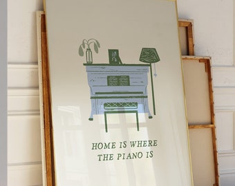 May include: A framed print with a light green and blue illustration of a piano with the text "Home is where the piano is".
