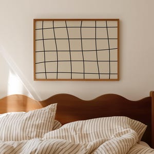 以下が含まれることがあります： 波型のヘッドボードが付いた木製のベッドフレームがある寝室のシーン。ベッドにはストライプの寝具と枕が置かれています。グリッドパターンが描かれた額入りのアートワークがベッドの上に飾られています。