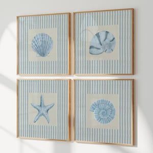 May include: A set of four square wall art pieces in light wood frames. Each print features a blue watercolor illustration of a different sea creature, including a scallop shell, a nautilus shell, a starfish, and a spiral shell on a striped background.