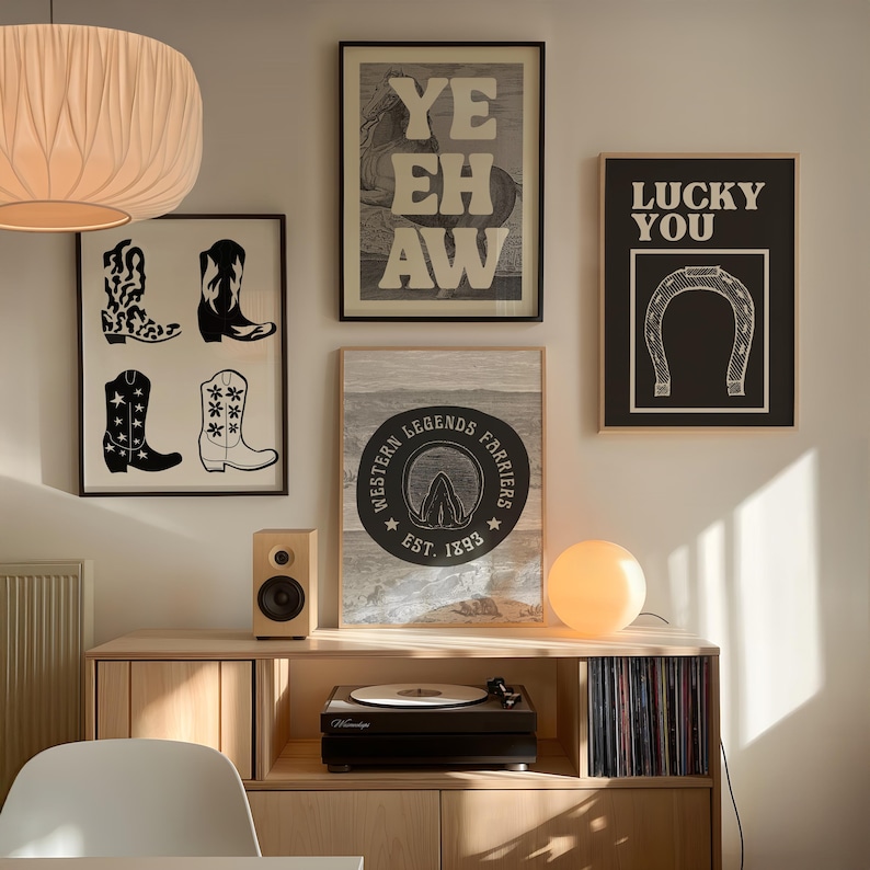 May include: A selection of framed art prints with a Western theme. The prints feature cowboy boots, the text "YE HAW", a horseshoe with the text "LUCKY YOU", and a circular emblem with the text "WESTERN LEGENDS FARRIERS EST. 1893".