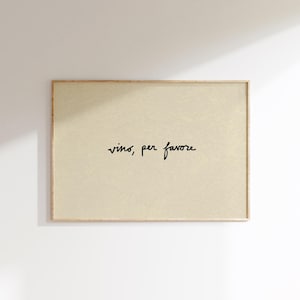 May include: A framed rectangular print with the words "vino, per favore" in black script on a beige background. The frame is a light brown color, and the print is hanging on a white wall.