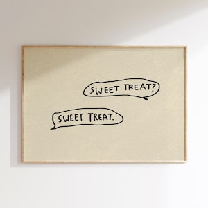 May include: A framed print featuring the text "SWEET TREAT?" and "SWEET TREAT." in black, handwritten-style lettering. The background is a light beige color, and the frame is a natural wood tone. The artwork is simple and modern.