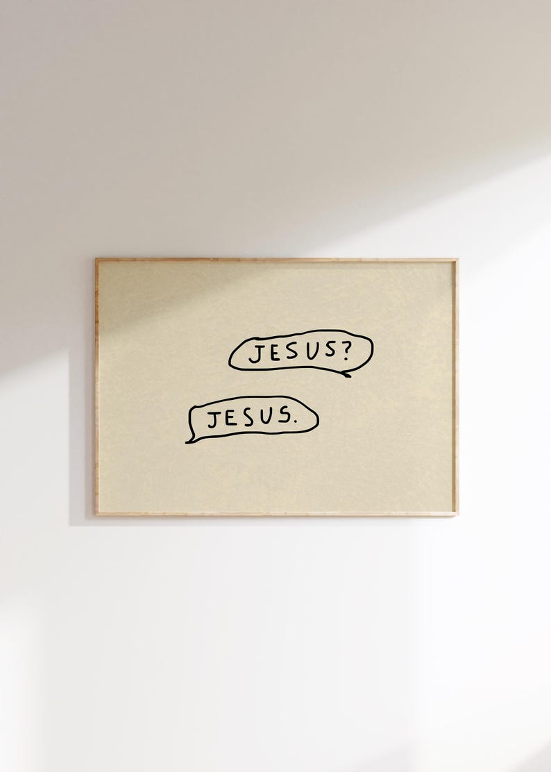 May include: A framed print with a beige background and the words "JESUS?" and "JESUS." in black, handwritten-style text within speech bubbles. The frame is a light brown color.