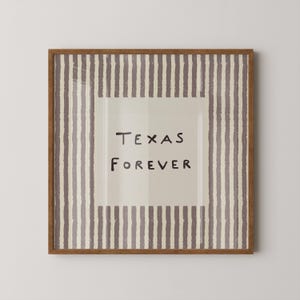 Pode incluir: Uma peça de arte de parede quadrada numa moldura de madeira com um painel central bege e o texto preto 'TEXAS FOREVER' escrito num tipo de letra simples desenhado à mão. A borda consiste em riscas verticais texturizadas em malva escuro e bege.
