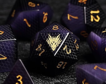 Könnte beinhalten: Satz von polyedrischen Würfeln in Lila und Schwarz mit goldenen Zahlen. Die Würfel haben ein strukturiertes, schuppenartiges Muster. Ein Würfel zeigt ein goldenes Drachenemblem. Für Tabletop-Spiele.