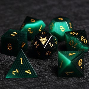 May include: A collection of seven polyhedral dice in shades of green and black, with gold numbering. The dice are arranged on a dark surface, showcasing various shapes, including a d20, d12, d8, d6, and a d4. One die features a gold dragon design.