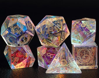 Peut inclure: Un ensemble de dés irisés avec des accents dorés et des motifs célestes. Les dés sont en verre et ont différentes formes, notamment un d4, un d6, un d8, un d10, un d12 et un d20.