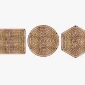 Pode incluir: Três quebra-cabeças de labirinto de madeira, cada um com uma forma diferente: um quadrado, um círculo e um hexágono. Os labirintos são todos intrincados e desafiadores.