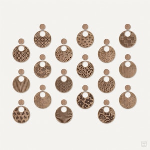 Op de afbeelding: Een set van 16 houten oorbellen met verschillende lasergesneden ontwerpen. De oorbellen zijn rond en hebben een gat in het midden. De ontwerpen omvatten geometrische patronen, dierenprints en bloemmotieven.