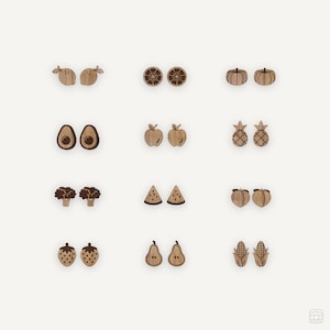 Puede incluir: Un conjunto de 10 pares de pendientes de madera con diferentes frutas y verduras, incluyendo limones, naranjas, calabazas, aguacates, manzanas, piñas, brócoli, sandías, melocotones, fresas, peras y maíz.