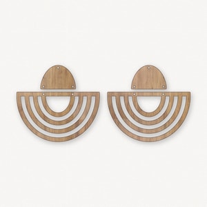 May include: A pair of wooden earrings with a half-circle shape and multiple concentric rings. The earrings are made of light brown wood and have a simple, modern design.