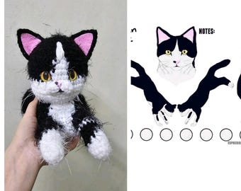 May include: A black and white crocheted cat toy with pink ears. The cat is sitting on a hand. The image also shows a pattern for crocheting a cat toy.