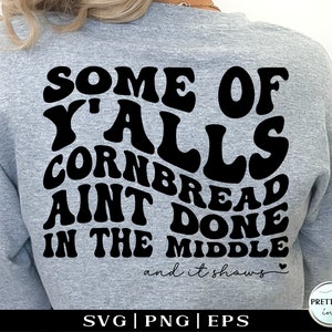 Peut inclure: Un sweat-shirt gris avec un texte noir qui dit "Some of Y'alls Cornbread Ain't Done in the Middle and it shows".
