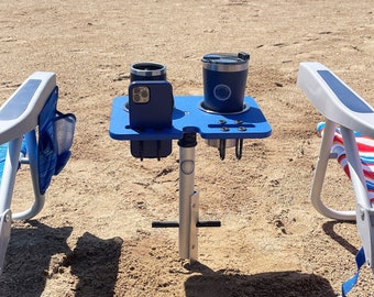 Beach table with stainless steel cup holders and interchangeable design, Marine-grade beach table. SandBar™ Click & Play system.