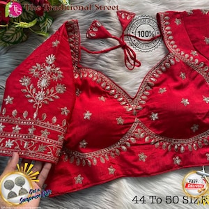 May include: A vibrant red blouse with intricate gold embroidery. The blouse features a deep V-neck and short sleeves, adorned with floral and leaf patterns. The text "The Traditional Street" and "44 to 50 SIZE" are visible. A "Premium Quality" badge is also present.