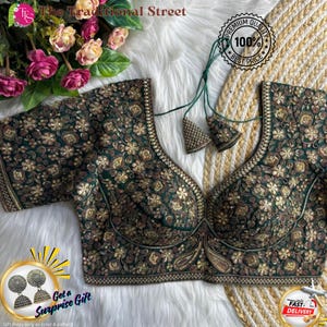 May include: A dark green embroidered blouse with gold floral patterns. The blouse has a deep V-neck and short sleeves. The text "The Traditional Street" is at the top. The image also includes the text "Premium Quality 100% Best Price" and "Get a Surprise Gift".