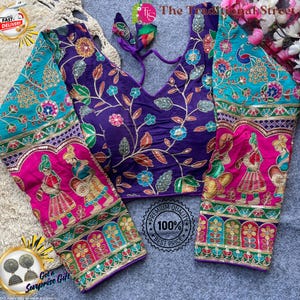 Pode incluir: Uma blusa bordada em roxo, turquesa e rosa, com desenhos florais e de figuras. A blusa tem mangas compridas e um decote em V profundo. O texto "The Traditional Street" é visível.