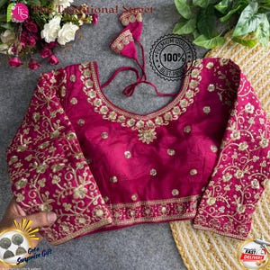Pode incluir: Uma blusa magenta com bordados dourados intrincados. A blusa apresenta mangas compridas e um decote redondo, adornado com padrões florais e de videira. O texto "The Traditional Street" é visível. A imagem também inclui o texto "Premium Quality 100% Best Price".
