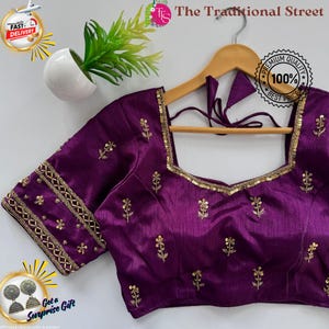 Pode incluir: Uma blusa roxa escura com bordados dourados e acabamentos de lantejoulas. O decote quadrado e as mangas curtas são adornados com padrões florais e geométricos. O texto "The Traditional Street" é visível.