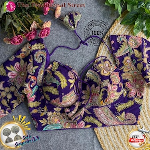 May include: A purple embroidered top with floral and paisley patterns. The top has a halter neck design and is embellished with gold and other colorful threads. The image also includes a decorative flower and the text "The Traditional Street".