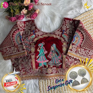 Pode incluir: Blusa bordada bordô com desenhos de pavão e casal. A blusa apresenta intrincados trabalhos de fios dourados e coloridos. O texto "The Traditional Street" é visível. Inclui um par de brincos de prata como presente.